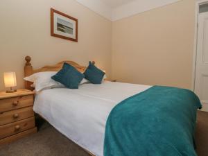 ein Schlafzimmer mit einem großen weißen Bett mit blauen Kissen in der Unterkunft Treleigh in Hayle + 11 Fotos