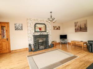 a living room with a fireplace and a mirror at Kate's Cottage in Rathmullan