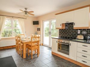 a kitchen with a table and a dining room at Kate's Cottage in Rathmullan