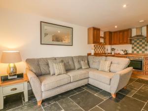 uma sala de estar com um sofá e uma mesa em Crift Farm Cottage em Bodmin