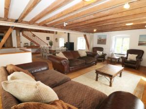 uma sala de estar com sofás de couro e uma mesa em Felin em Llanfairpwllgwyngyll