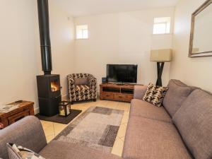 a living room with a couch and a fireplace at Watermill Cottage in Chathill