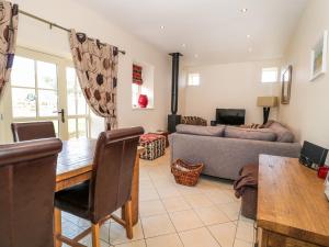 a living room with a table and a couch at Watermill Cottage in Chathill
