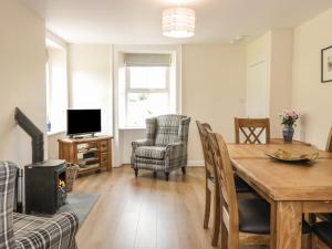 a living room with a dining room table and a fireplace at Bonjedward Mill Farm Cottage in Jedburgh