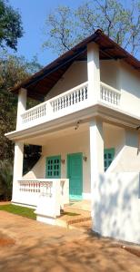 a small white house with a green door at Casa Aluizio in Assagao