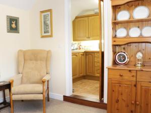 sala de estar con silla y cocina en Highbury Cottage, en Shrewsbury