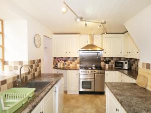 a kitchen with white cabinets and a stove top oven at 83 Seatown in Buckie