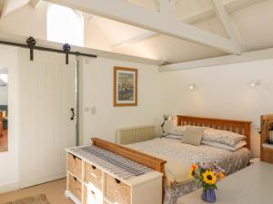 Schlafzimmer mit einem Bett und einem Fenster in der Unterkunft The Daffodil Shed in Yelverton