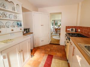 een keuken met witte kasten en een tegelvloer bij Clearview in Lydford