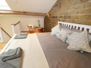a large bed in a room with a brick wall at The Stables in Huddersfield