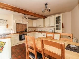 a large kitchen with a wooden table and chairs at Hillcrest in Buxton