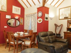 comedor con paredes rojas, mesa y sillas en Gelli Glud, en Eglwys-Fâch