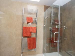 a towel rack in a bathroom with orange towels at Garden Cottage in Perth