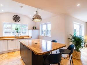 uma cozinha com uma grande mesa de madeira e cadeiras em Farm View House em Melton Mowbray