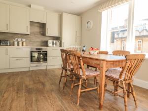 a kitchen with a wooden table and chairs at Postmaster's Lodging in Cheltenham