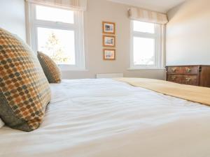 a bedroom with a large bed with two windows at Postmaster's Lodging in Cheltenham
