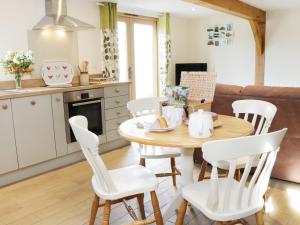 a kitchen and dining room with a wooden table and chairs at Acorn Cottage in Ludlow