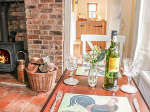 a table with a bottle of wine and a fireplace at Little Pound House in Mamble