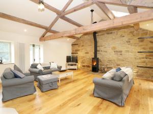 a living room with two couches and a brick wall at Morgan's Barn in Huddersfield