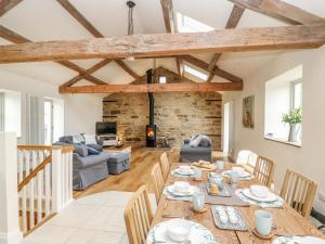 cocina y sala de estar con mesa de madera y sillas en Morgan's Barn en Huddersfield