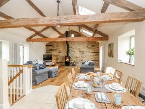 eine Küche und ein Wohnzimmer mit einem Holztisch und Stühlen in der Unterkunft Morgan's Barn in Huddersfield