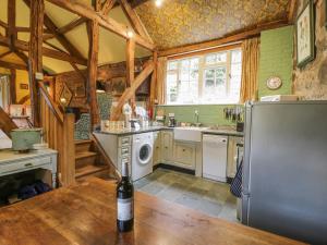 a kitchen with a bottle of wine on a table at Dolgenau Hir - The Barn in Trefeglwys