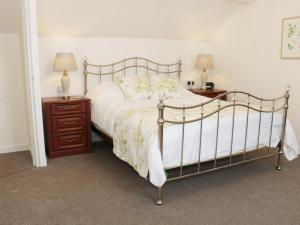 een slaapkamer met een bed en twee nachtkastjes met lampen bij The Hayloft in Shelve