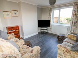 sala de estar con 2 sofás y TV de pantalla plana en 27 Whitegates en Great Yarmouth