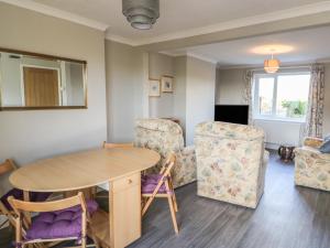 ein Wohnzimmer mit einem Tisch und 2 Stühlen in der Unterkunft 27 Whitegates in Great Yarmouth