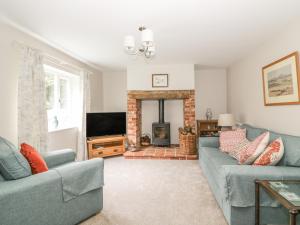 a living room with two blue couches and a fireplace at Greenacres in Norwich