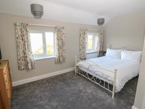 a bedroom with a bed and two windows at 27 Whitegates in Great Yarmouth
