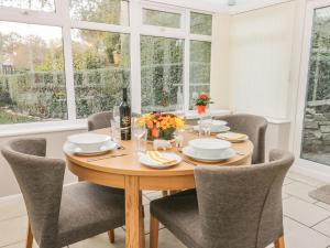 a dining room with a table and chairs and windows at Yew Court Cottage in Scarborough