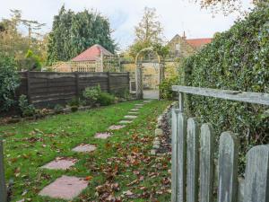 a garden with a wooden fence and a yard at Yew Court Cottage in Scarborough