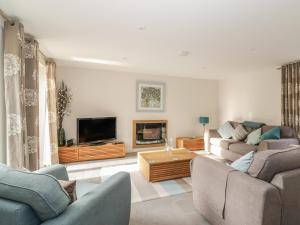 a living room with two couches and a tv at Cherry Tree Cottage in Norwich