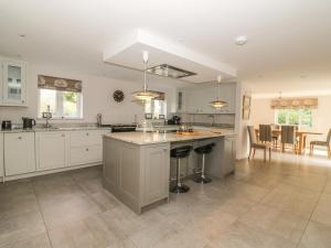 a large kitchen with white cabinets and a large island at Cherry Tree Cottage in Norwich