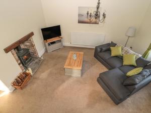 sala de estar con sofá y chimenea en Hare & Hounds House, en Hexham
