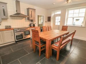 a kitchen with a wooden table and wooden chairs at Hare & Hounds House in Hexham