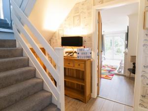 a room with a staircase with a tv and a door at Gwelfor in Cemaes Bay