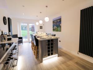 a kitchen with a large island with chairs and a bar at Gwelfor in Cemaes Bay