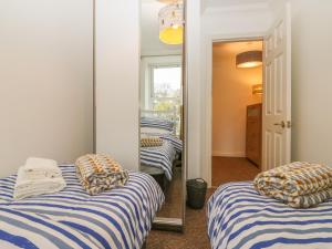 a room with two beds and a mirror at Cottage 1 Newcourt in Torquay