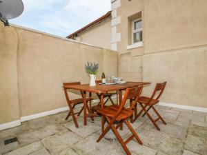 a wooden table and chairs on a patio at Cottage 1 Newcourt in Torquay +13 photos