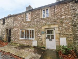an old stone house with a white door at 2 Storrs Cottages in Carnforth