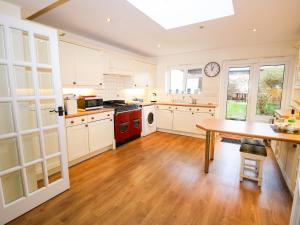 a kitchen with white cabinets and a wooden table at Tovah in Yarmouth