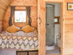 a bedroom with a bed in a log cabin at Dingle Den in Hereford