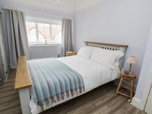 sypialnia z dużym białym łóżkiem i oknem w obiekcie Sunlight Soap Cottage w mieście Wirral