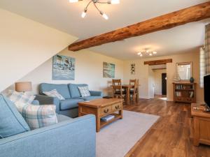 sala de estar con sofá azul y mesa en Rose Cottage en Barnstaple