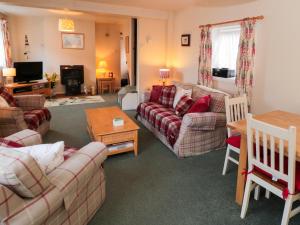 ein Wohnzimmer mit 2 Sofas und einem Tisch in der Unterkunft Fishermans Cottage in Saltburn-by-the-Sea