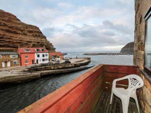 ein weißer Stuhl auf einem Balkon mit Blick auf das Wasser in der Unterkunft Fishermans Cottage in Saltburn-by-the-Sea