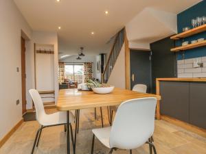 a kitchen and dining room with a wooden table and white chairs at The Greenhouse in Skipton