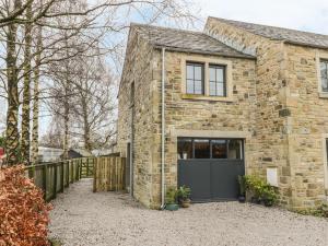 a brick house with a grey garage at The Greenhouse in Skipton